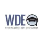 Wyoming Department of Education (WDE) logo featuring bold blue letters “WDE” alongside a circular icon with a graduation cap in black and gray.