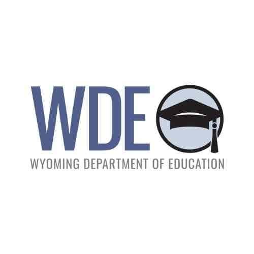 Wyoming Department of Education (WDE) logo featuring bold blue letters “WDE” alongside a circular icon with a graduation cap in black and gray.