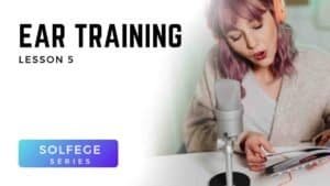 Woman with headphones singing into microphone while reading music during Voice 360 Solfège Series ear training lesson