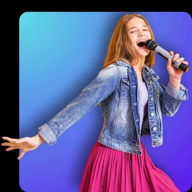 Teen singer in denim jacket and pink skirt performing confidently with microphone