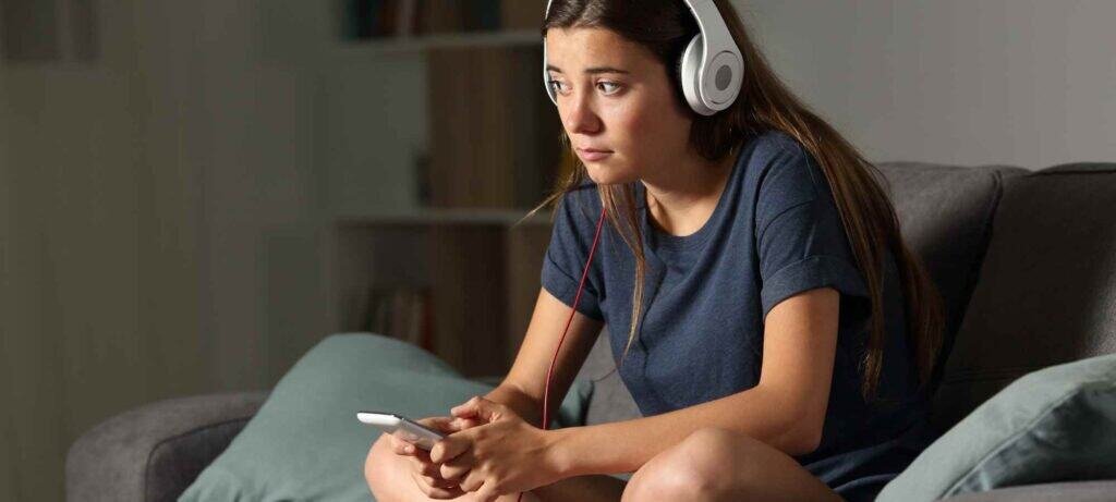 Teen homeschool student learning singing online with headphones
